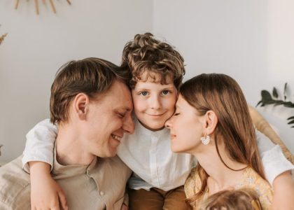 A joyful family moment with parents and their son embracing indoors.